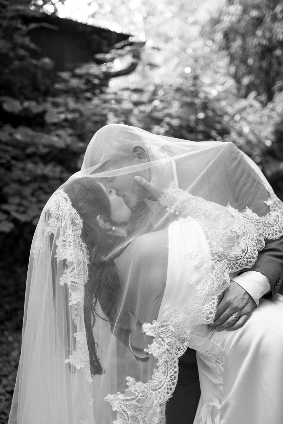 Couple de mariés sous le voile en noir et blanc